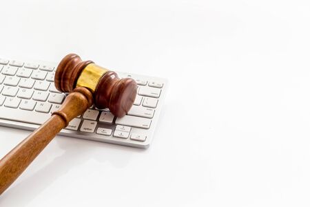 Judge gavel near keyboard - desk of contemporary lawyer - on white background copy spaceの写真素材