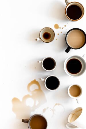 Different cups of coffee on white table top-down.の写真素材