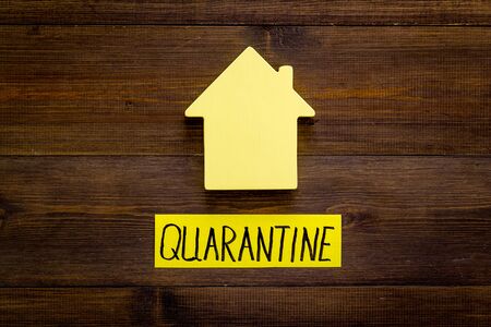 Quarantine stay at home - isolation, self-isolaton. House on wooden table top viewの写真素材