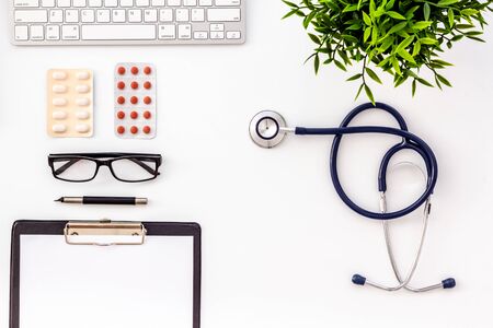 Doctor office desk with medicine and tablet. White table top view copy spaceの写真素材