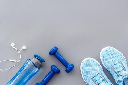 Fitness background with sneakers, dumbbells and headphones on grey table top view copy spaceの写真素材