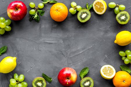 Oranges, lemon, apple, kiwi and grape - healthy food concept with fruits - on grey background top-down.の写真素材