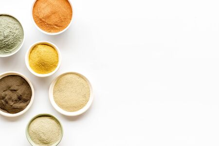 Yellow, red, white, blue and black cosmetic clay on white table top view.の写真素材