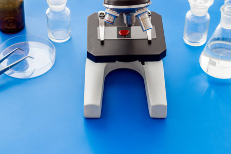 Bood testing with microscope in laboratory. Equipment on blue background