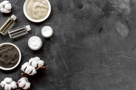 Set of cosmetic clays for facial beauty face mask on black table top-down frame space for text