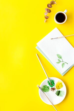 Drawing plants. Brushes and picture on yellow background top-down copy spaceの写真素材