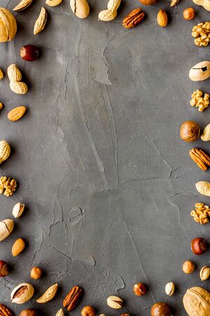 Nuts background - healthy snacks concept - on grey table top-down frame copy spaceの写真素材