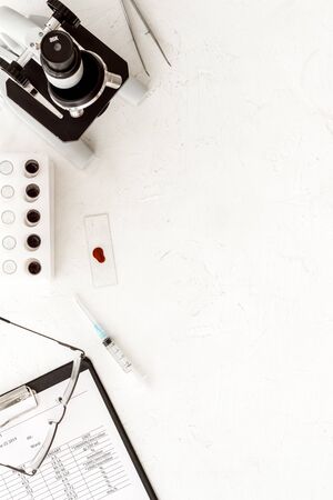 Microscope medical reserch. Blood sample for analysis. White table top view copy spaceの写真素材