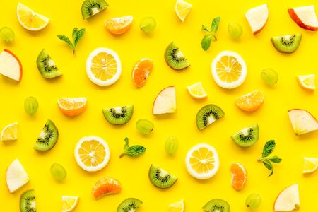 Colorful fruit pattern with citrus and kiwi slices - fresh summer fruits - on yellow background...