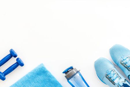 Crossfit equipment. Dumbbells and sneakers on white background top-down copy spaceの写真素材
