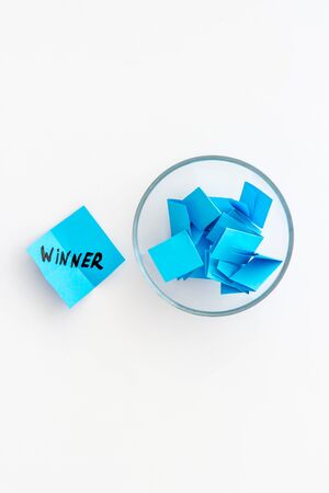 Winner selection. Paper pieces for lottery in vase on white background top view copy spaceの写真素材