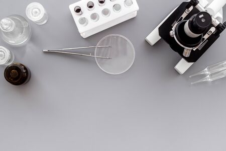 Bood testing with microscope in laboratory. Equipment on grey background top view copy spaceの写真素材