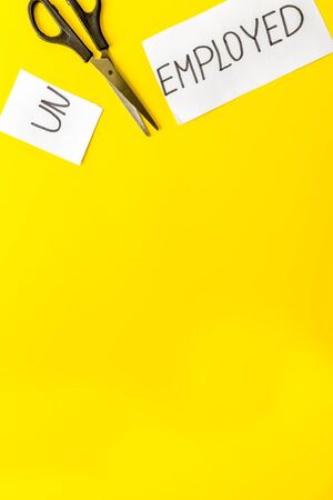 Unemployed - employed - torn paper sheet, sciccors on yellow background top view copy spaceHiring concept. .の写真素材