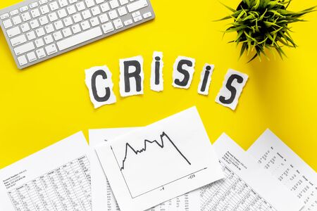 World financail crisis - arrow down, markets crash - on yellow office desk top view.の写真素材