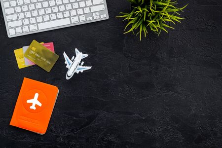 Flight booking - passport, cards, computer keyboard - on black background top view copy space
