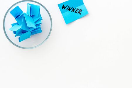 Paper pieces - random winner selection - white desk top-down copy spaceの写真素材