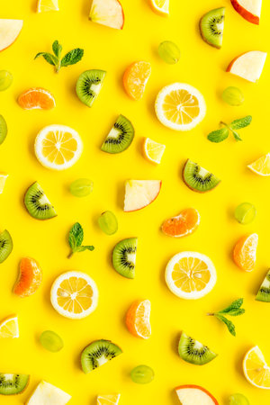Colorful fruit pattern with citrus and kiwi slices - fresh summer fruits - on yellow background...