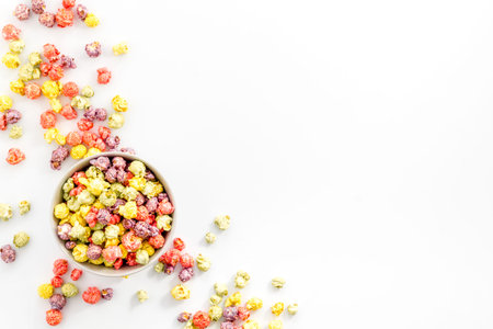 Colored popcorn in bowl on white background top view.の写真素材