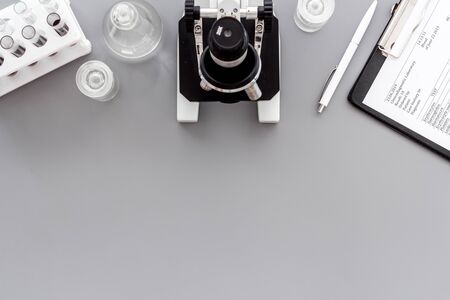 Microscope medical reserch. Blood sample for analysis. Grey table top view copy spaceの写真素材