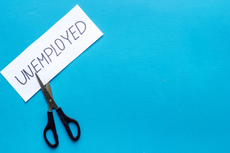 Unemployed - employed - torn paper sheet, sciccors on blue background top view space for text....
