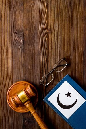 Islam sybmbol crescent and star near gavel and book on wooden table top view. Religious conflict concept. Copy spaceの写真素材