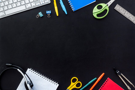 E-learning. Stationery, headphones and keyboard on black table top-down frame copy space