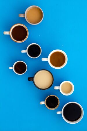 Lots of coffee on blue desk top-down.の写真素材