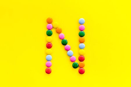 Letter N - alphabet made with sweets on yellow from above.の写真素材