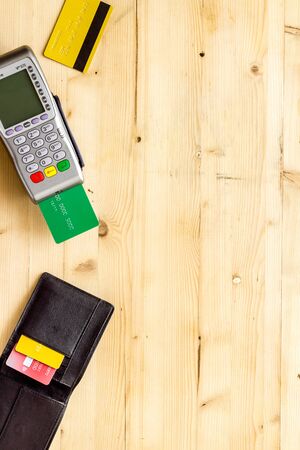 Payment by credit card. Bank terminal on wooden background top view copy spaceの写真素材