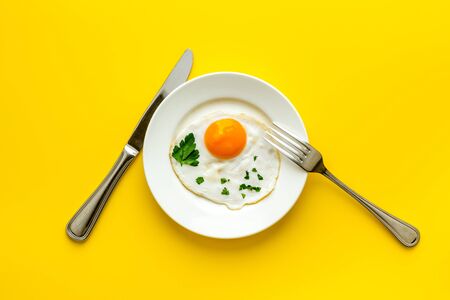 Fried eggs on plate - yellow table top viewの写真素材
