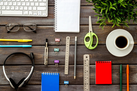 Online education. Computer keyboard, stationery on wooden desk top-down flat lay pattern