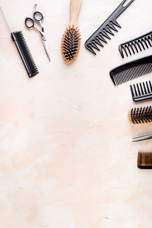 Combs, hairbrush, scissors - hairdresser eqiupment - on beige table top-down space for textの写真素材