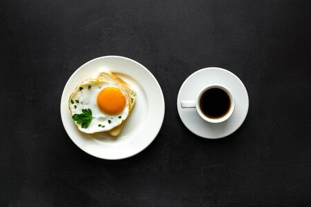 Fried eggs sandwich on plate - black dinner table top viewの写真素材