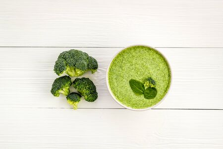 Broccoli cream soup on white wooden background top viewの写真素材