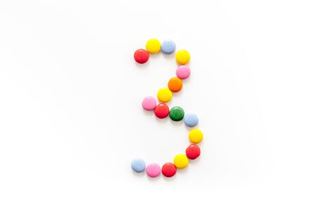 Number 3 - three - lined with sweets on isolated top-down.の写真素材