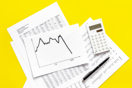 World financail crisis - arrow down, markets crash - on yellow office desk top view.