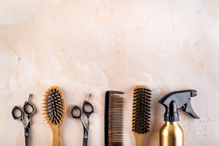 Hairdresser set in beauty salon. Combs, scissors, spray on beige desk top-down copy spaceの写真素材
