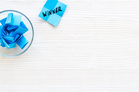 Winner selection. Paper pieces for lottery in vase on white wooden background top view copy spaceの写真素材