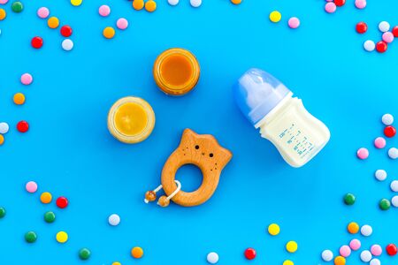 Children flat lay with toys and candy on blue background top view