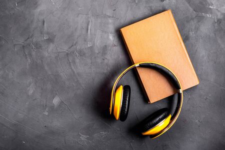 audio book concept with headphones on grey table from above copy space