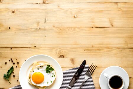 Fried eggs sandwich on plate - light wooden desk from above space for textの写真素材