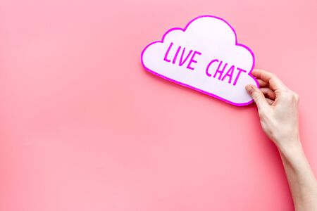 Live chat concept - bubble in hands on pink table top viewの写真素材