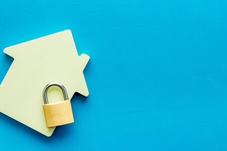Security concept. House and lock on blue background top view copy spaceの写真素材