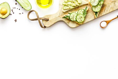 cooking vegan avocado sandwiches. Cutting board on white table copy space