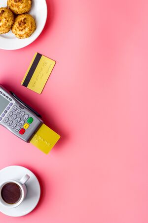 Payment by credit card. Terminal on pink restaurant desk from above copy spaceの写真素材