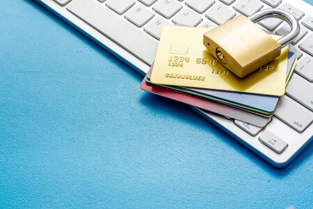 data security concept with credit card with keyboard on blue desk copy space