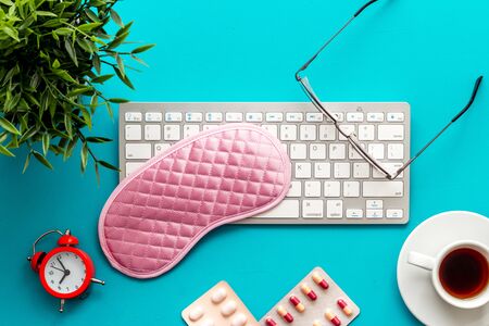 fatigue concept. Sleep mask on office desk from above.の写真素材