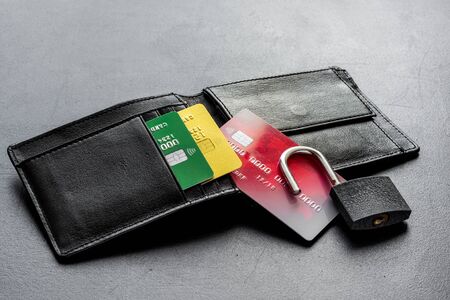 credit card hacked - security lock open and wallet - on black table