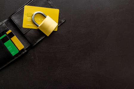 Credit card data security concept with lock on black desk top view copy space