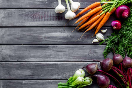 Flat lay of fresh vegetables and greenery on wooden table top-down copy space